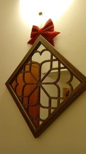 a mirror with a red bow on a wall at i 3 falchi Bed & Breakfast 