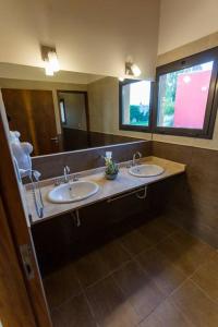 a bathroom with two sinks and a large mirror at Estancia Yolanda C1 - by Inside in Ciudad Lujan de Cuyo