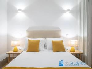 een slaapkamer met een groot wit bed met 2 lampen bij Porto Almada Design Loft in Porto