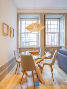 een eetkamer met een glazen tafel en stoelen bij Porto Almada Design Loft in Porto