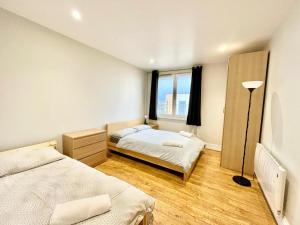 1 dormitorio con 2 camas y ventana en London Modern Flat near transports, en Londres