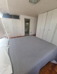 a bedroom with a bed and white cabinets at Las condes, Amplia habitación con baño privado in Santiago
