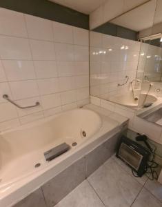 un bagno bianco con vasca e lavandino di Las condes, Amplia habitación con baño privado a Santiago