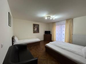 Una habitación de hotel con dos camas y una ventana. en Vila Alma, en Băile Felix