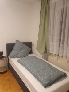 uma cama com duas almofadas ao lado de uma janela em ST4 Apartment em Triberg