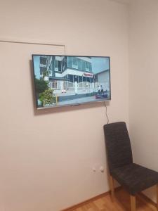 uma cadeira preta e uma televisão na parede em ST4 Apartment em Triberg