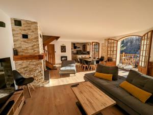a living room with a couch and a stone fireplace at Magnifique Chalet avec Balnéothérapie in Roubion