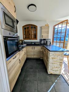 a kitchen with wooden cabinets and a blue counter top at Magnifique Chalet avec Balnéothérapie in Roubion