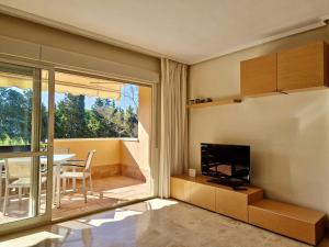 ein Wohnzimmer mit einem TV und einem Esszimmer in der Unterkunft SR Carib Playa Marbella in Marbella
