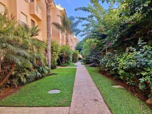 einen Fußweg durch ein Resort mit Palmen und Gras in der Unterkunft SR Carib Playa Marbella in Marbella
