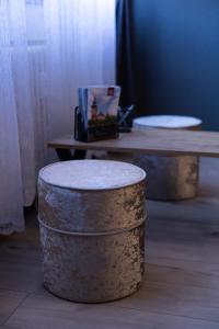 two wooden stools sitting in front of a table at T - Polis in Subotica
