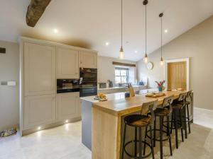 a kitchen with a large island with bar stools at 4 Bed in Skipton 84017 