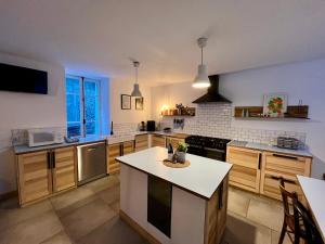 a kitchen with wooden cabinets and a white counter top at Maison De La Muzelle, Venosc - Les Deux Alpes in Vénosc