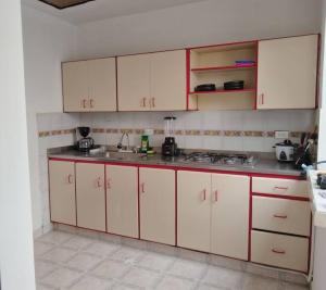 eine Küche mit weißen Schränken und einem Waschbecken in der Unterkunft Hermoso y cómodo apartamento.en Pereira in Pereira