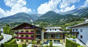 uma vista para uma casa com montanhas ao fundo em Hotel Obermoosburg em Coldrano