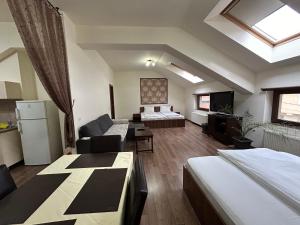 Habitación con 2 camas y sala de estar. en Vila Alma, en Băile Felix