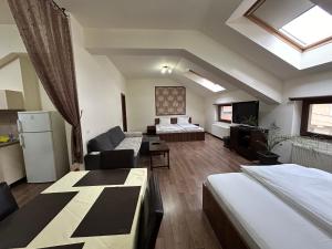 Una habitación con dos camas y una sala de estar. en Vila Alma, en Băile Felix