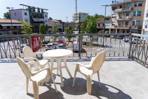 - Balcón con mesa blanca y 4 sillas en BnB Martin, en Jesolo