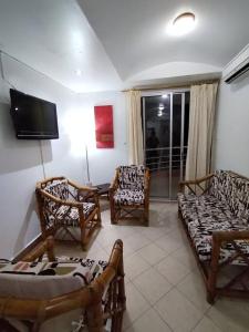 ein Wohnzimmer mit Stühlen und einem Flachbild-TV in der Unterkunft Atacames Hermosa Vista y Comodidad in Atacames