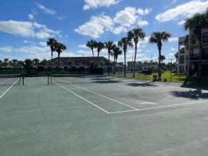 a tennis court with palm trees in the background at Ocean Village Club in Saint Augustine