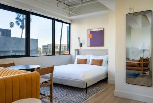 a hotel room with a bed and a table at Kasa Sunset Los Angeles in Los Angeles