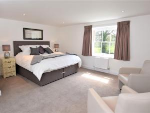a bedroom with a bed and a couch and a chair at 5 Bed in Wroxham 56103 in Hoveton