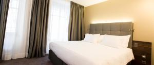 En eller flere senger på et rom på Hôtel des Voyageurs Boutique