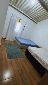 Cette chambre dispose d'un lit et de parquet. dans l'établissement Lindo sitio inserido a natureza, à Mogi das Cruzes