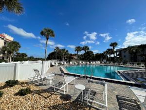 ein Pool mit einem Haufen Stühle und einem Tisch in der Unterkunft Ocean Village Club B-17 in St. Augustine