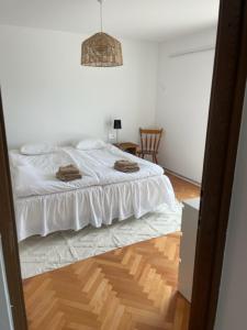 a bedroom with a white bed and a wooden floor at Rabac sea view in Rabac +3 photos