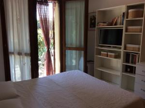 a bedroom with a bed and a tv and a window at affitto appartamento sul mare in Senigallia