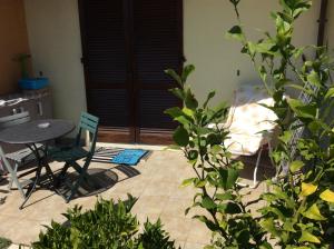 a patio with a table and chairs and a bed at affitto appartamento sul mare in Senigallia