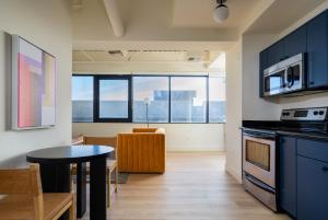 a kitchen with blue cabinets and a table in a room at Kasa Sunset Los Angeles in Los Angeles