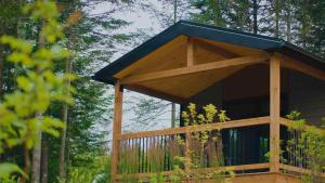 a gazebo with a blue roof in a forest at Nordique spa Stoneham in Stoneham
