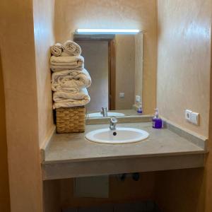 a bathroom with a sink and a stack of towels at Panorama Complex in Tahannout