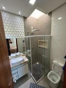 y baño con ducha, aseo y lavamanos. en Apartamento Porto Villa dos Diamantes 22 en Porto Seguro