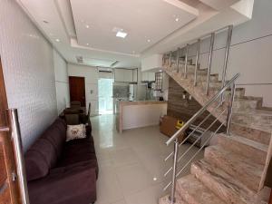 a living room with a couch and a staircase at Apartamento Porto Villa dos Diamantes 22 in Porto Seguro