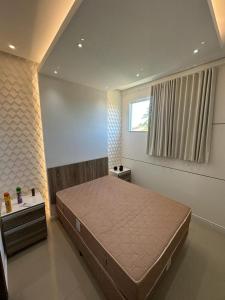 a bedroom with a large bed and a window at Apartamento Porto Villa dos Diamantes 22 in Porto Seguro