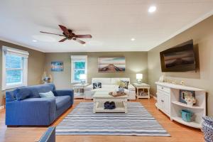 a living room with a blue couch and a ceiling fan at Family-Friendly Twin Lakes Home Near Lake Mary! in Twin Lakes