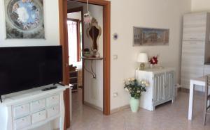 a living room with a television and a vase of flowers at affitto appartamento sul mare in Senigallia