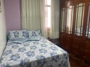 ein Schlafzimmer mit einem Bett mit einer blauen und weißen Decke in der Unterkunft Largo do Machado Estilo in Rio de Janeiro