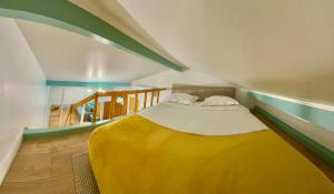 een slaapkamer met een bed met een gele deken bij Canarias Bungalow in Saint-Jeannet
