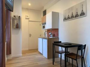a small kitchen with a table and chairs in it at Studio N1 plein centre ville in Rouen