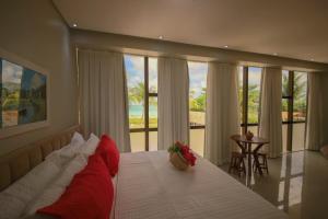 a bedroom with a bed with a view of the ocean at Obi exclusive pousada in Ponta do Mangue +101 photos