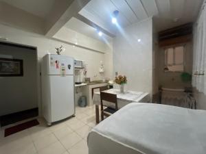 eine Küche mit einem weißen Kühlschrank und einem Tisch in der Unterkunft Largo do Machado Estilo in Rio de Janeiro