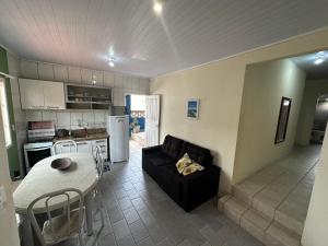 eine Küche und ein Wohnzimmer mit einem Sofa und einem Tisch in der Unterkunft Apartamentos próximo ao Mar in Bombinhas