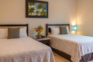 2 letti posti uno accanto all'altro in una camera da letto di Villa Palmeras a Cancún