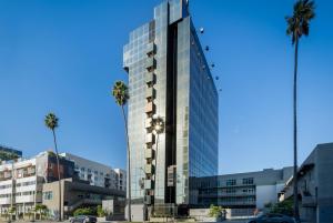 un edificio de cristal alto con palmeras delante en Kasa Sunset Los Angeles en Los Ángeles