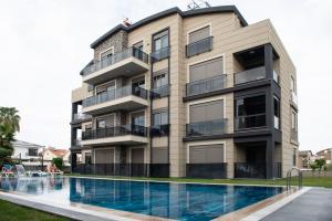 an apartment building with a swimming pool in front of it at Living Dream Apartment DUPLEX BELEK in Belek