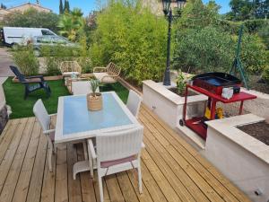 a patio with a table and a grill on a deck at Appartement Vacances ZEN in Fréjus